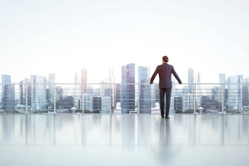 Geschäftsmann auf Dachterrasse blickt auf moderne Skyline, Business Vision